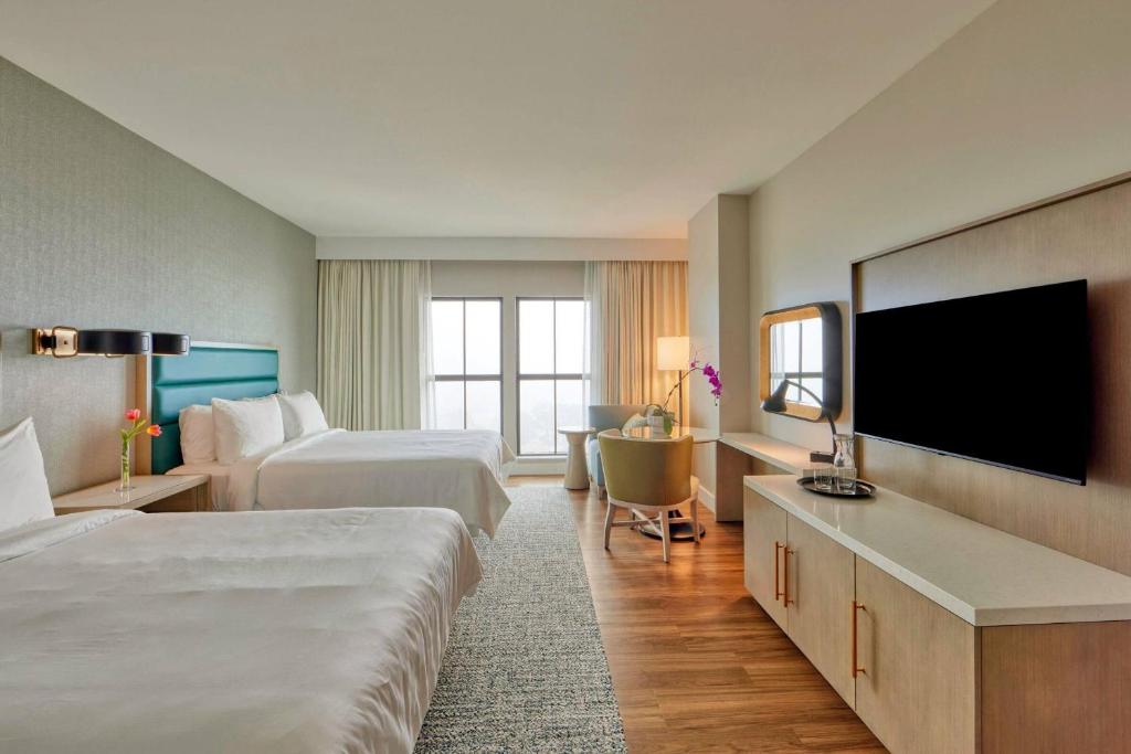德斯坦Hotel Effie Sandestin Resort, Autograph Collection的一间有两张床和一台平板电视的酒店房间