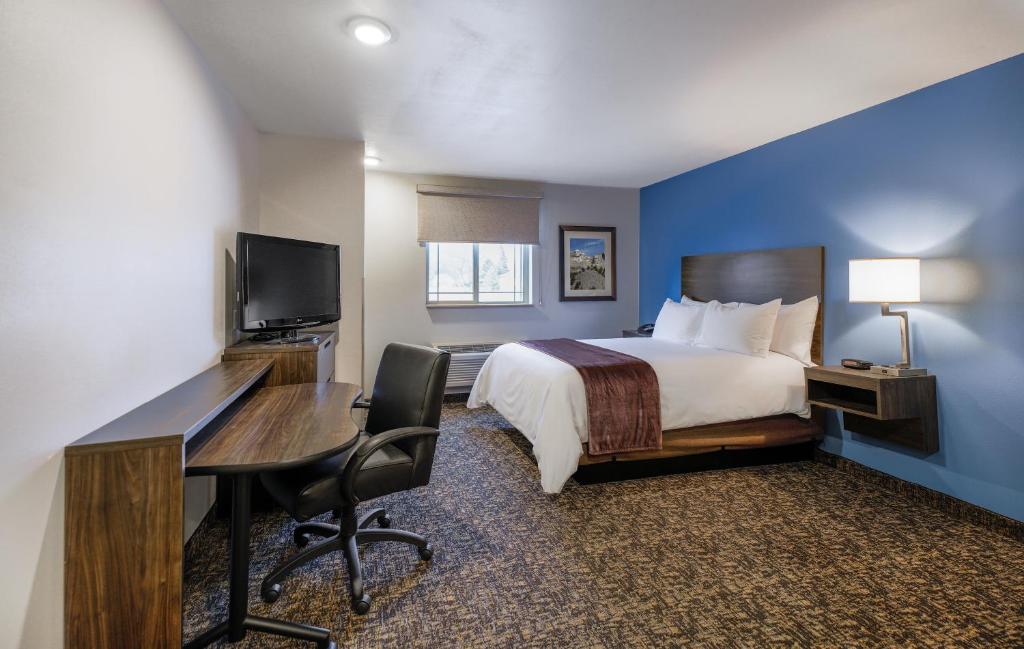 卡森市My Place Hotel-Carson City, NV的一间配有床、书桌和电脑的酒店房间