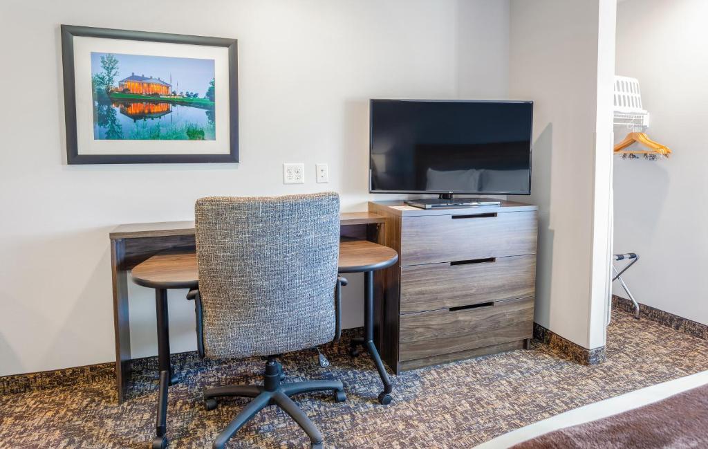 卡森市My Place Hotel-Carson City, NV的客房设有书桌、电视、桌子和椅子。