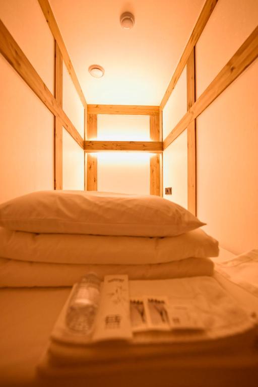 首尔Hanok Hotel DAAM Seoul的一间设有两个枕头的房间和一张桌子上的书