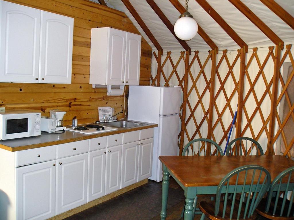 Harden Flat约塞米蒂湖区21号河滨圆顶帐篷的厨房配有白色橱柜、桌子和冰箱。