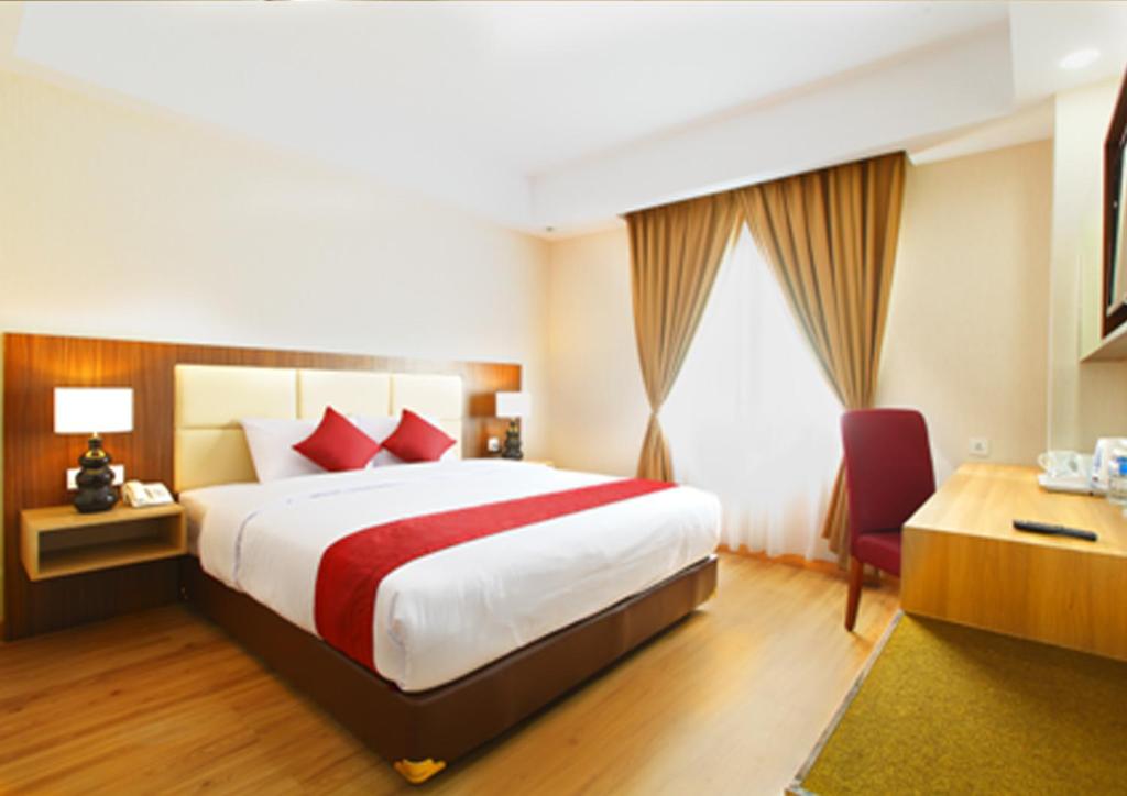 当格浪班达拉果园酒店的一间设有大床和窗户的酒店客房
