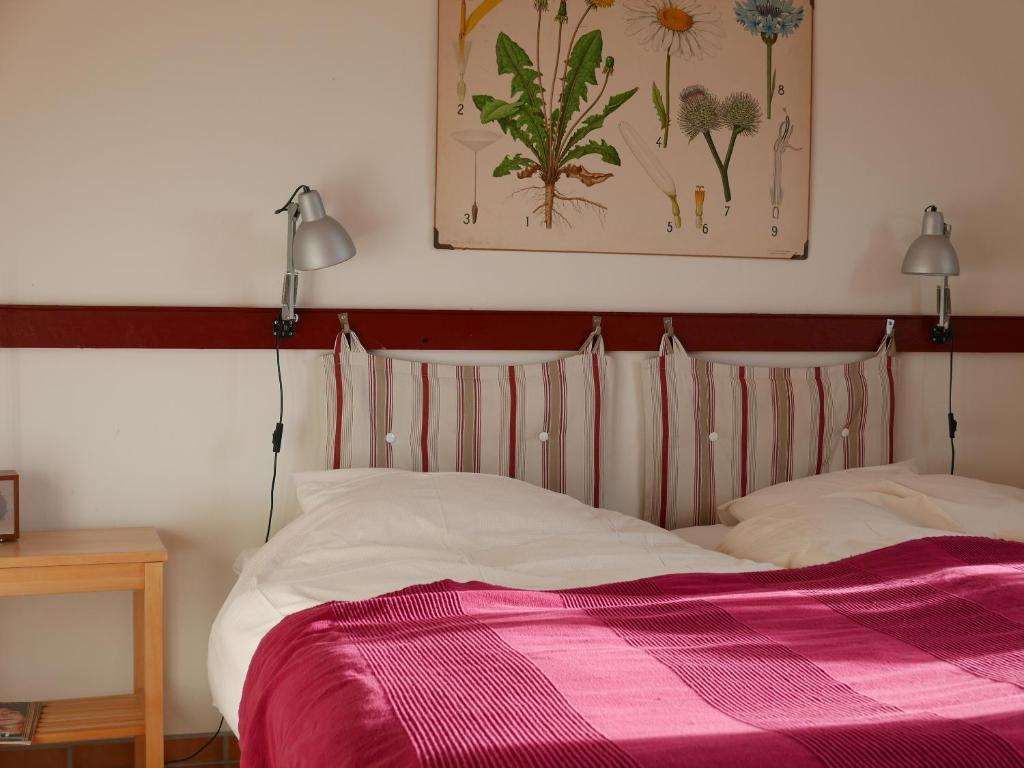 Tyfta里坎德酒吧及博恩德酒店的一间卧室配有一张带粉色毯子的床