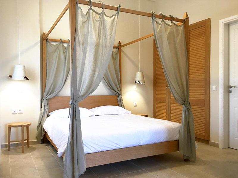 RachesAria Monte Villas的一间卧室配有一张带蚊帐的四柱床