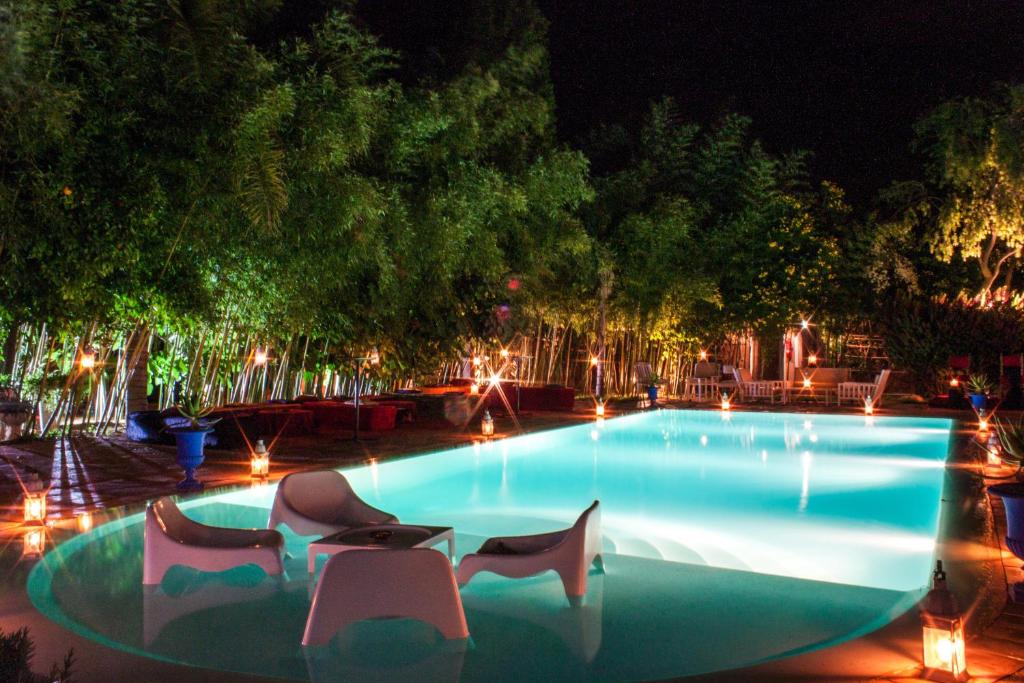 马拉喀什布莱德农家乐的夜间游泳池,配有椅子和灯