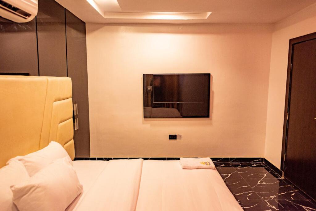 AridaRadiant Hotel and Suites的客房设有一张床和一台平面电视。