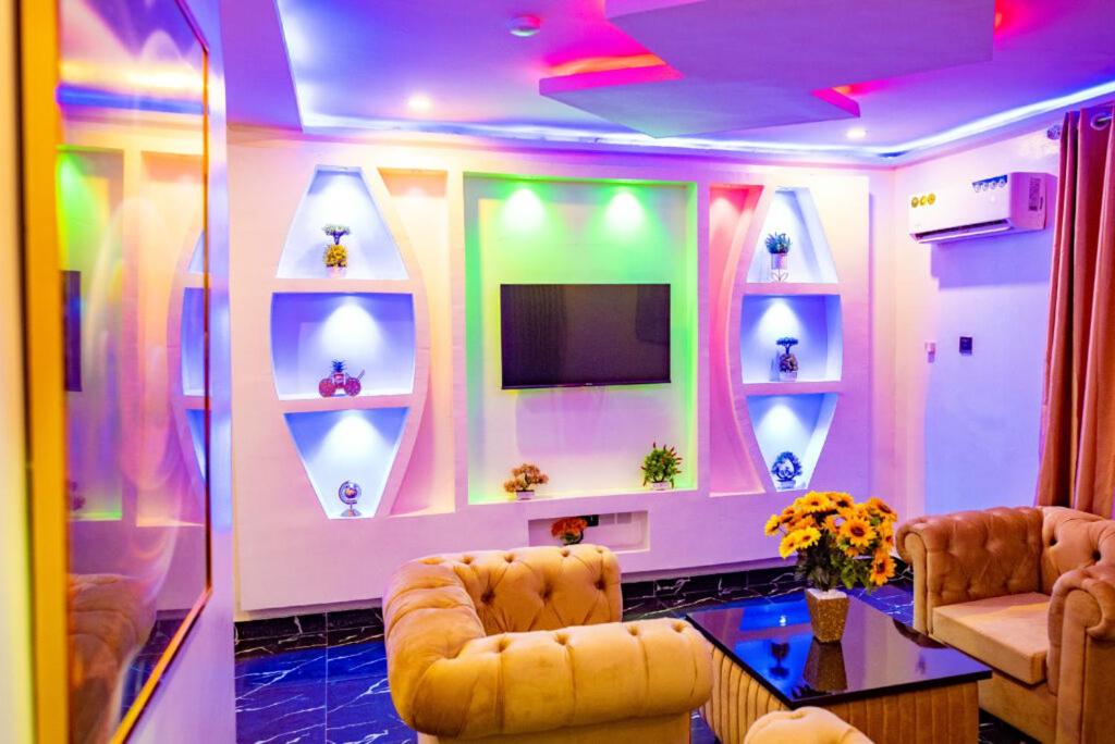 AridaRadiant Hotel and Suites的配有电视、沙发和桌子的客房
