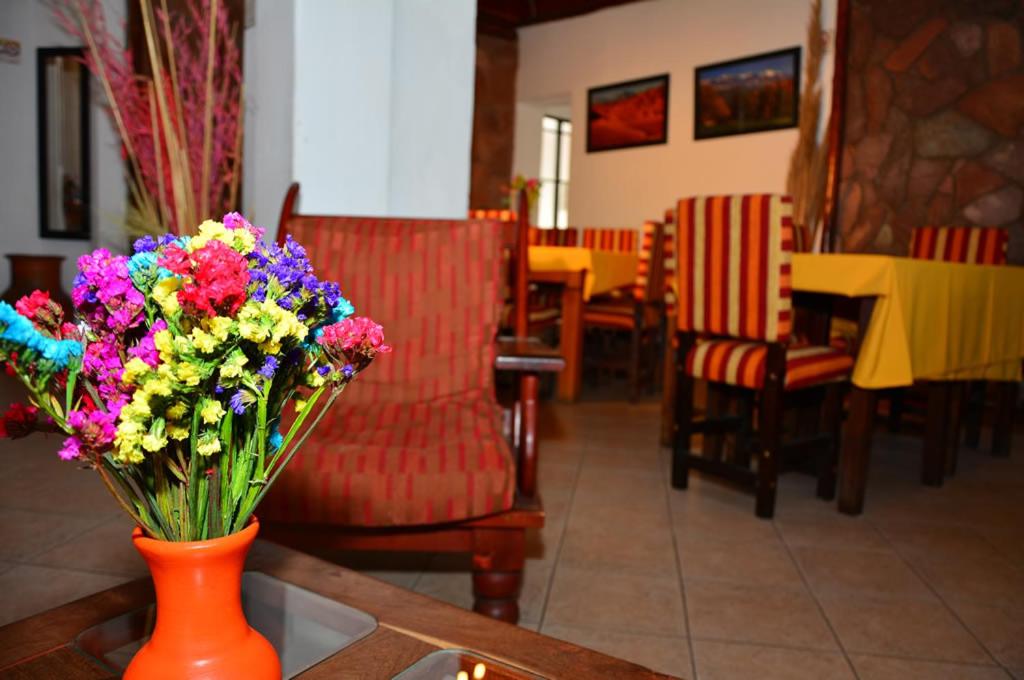 萨尔塔希拉尔达酒店的橙色花瓶,桌子上满是五颜六色的花朵