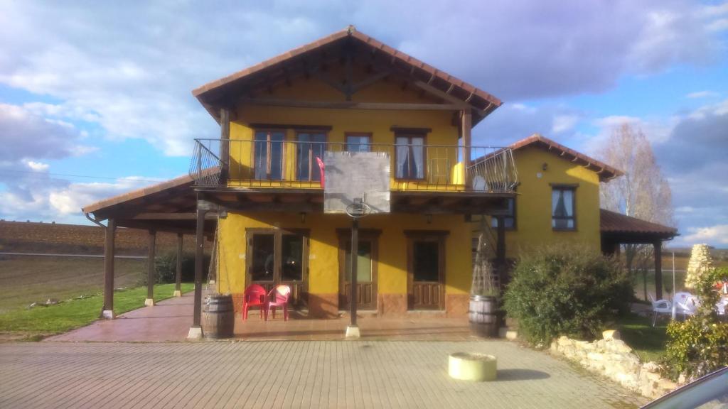 VallecilloCasarural Vallecillo的黄色房子的顶部设有阳台