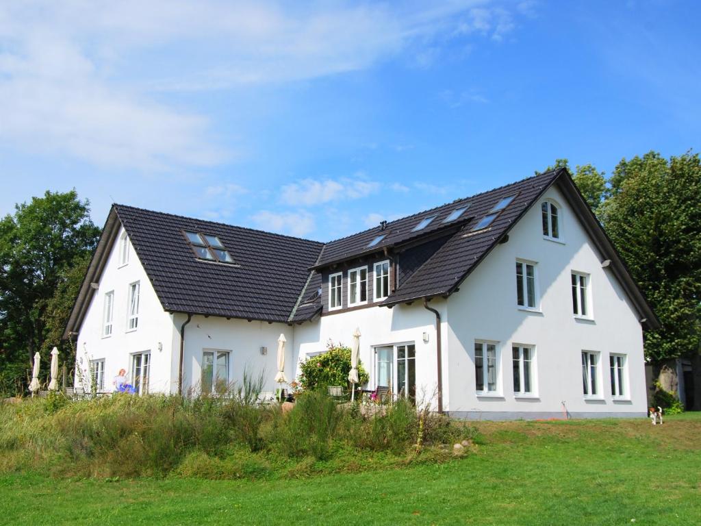 克洛斯特Ferienwohnung Hiddensee Hitthim的黑色屋顶的白色房子