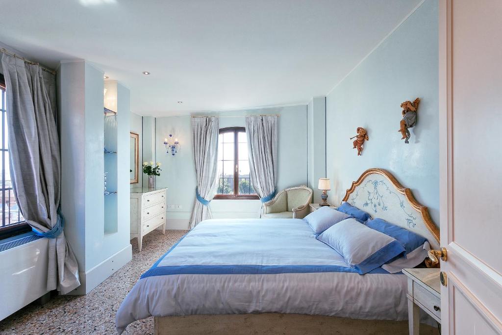 威尼斯泻湖景豪华公寓酒店的一间卧室配有一张蓝色墙壁和窗户的床