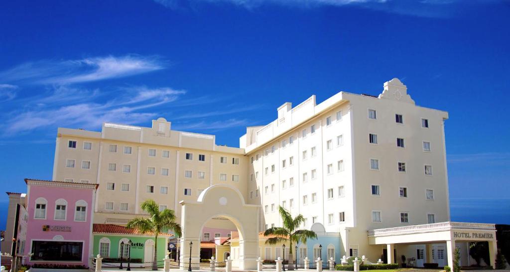 圣路易斯普瑞米尔酒店的一座白色的大建筑,前面有棕榈树
