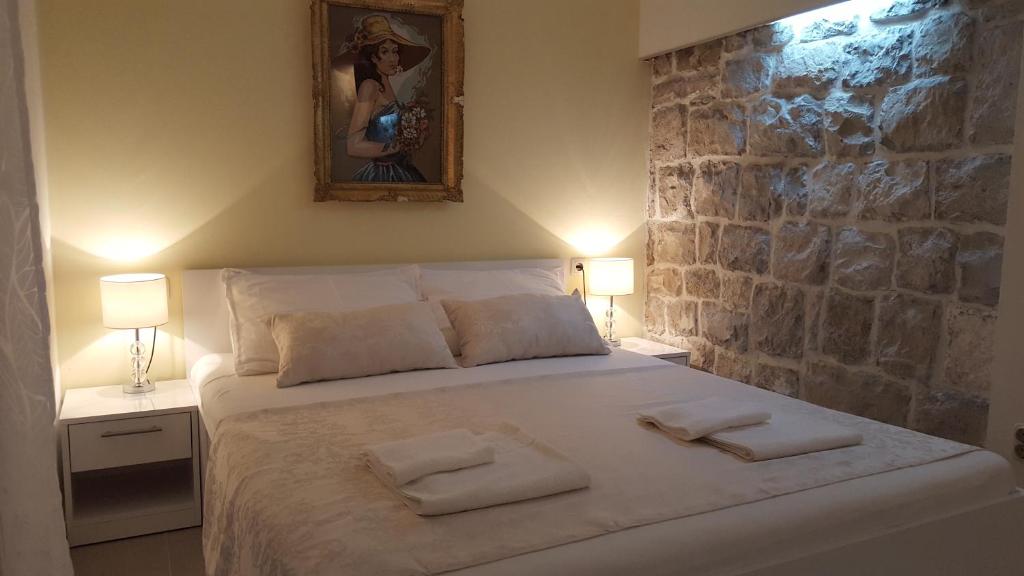 斯普利特华伦天奴酒店的一间卧室配有一张大床和两条毛巾