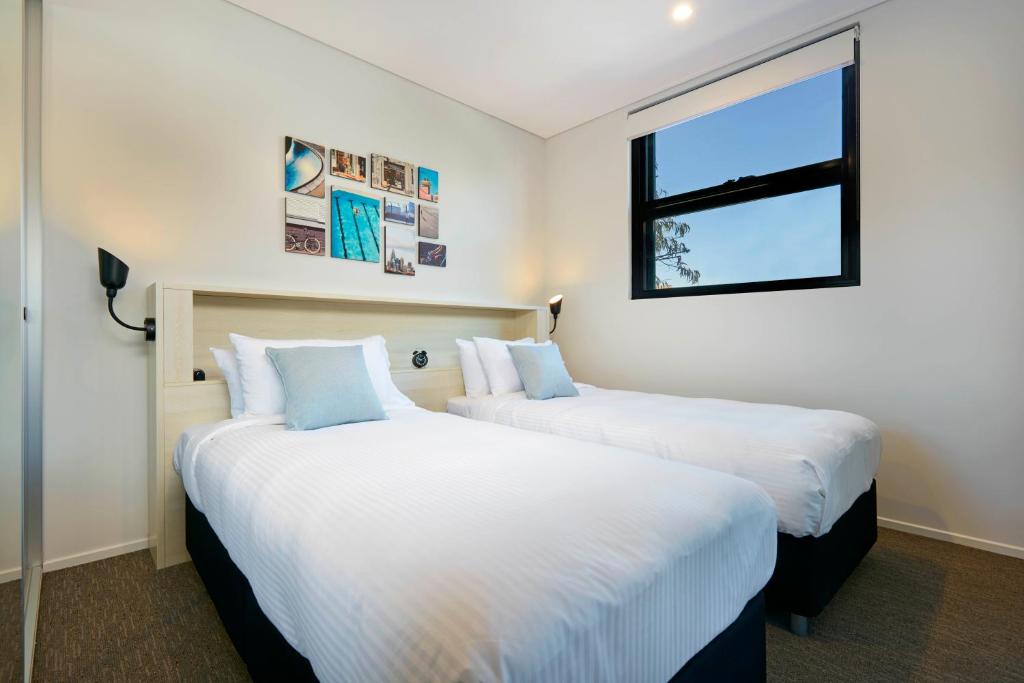 悉尼维鲁坎珀道酒店的带窗户的客房内的两张床
