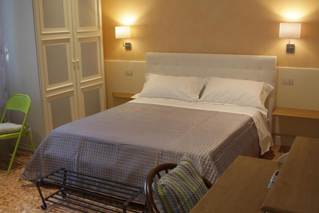 里米尼艾普罗普雷圣吉罗拉莫住宿加早餐旅馆的卧室配有一张床和一张桌子及椅子