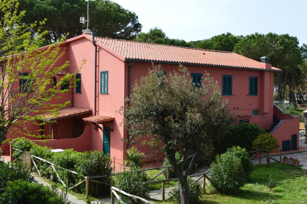 阿尔比尼娅Camping Village Bocche D'Albegna的前面有一棵树的粉红色房子