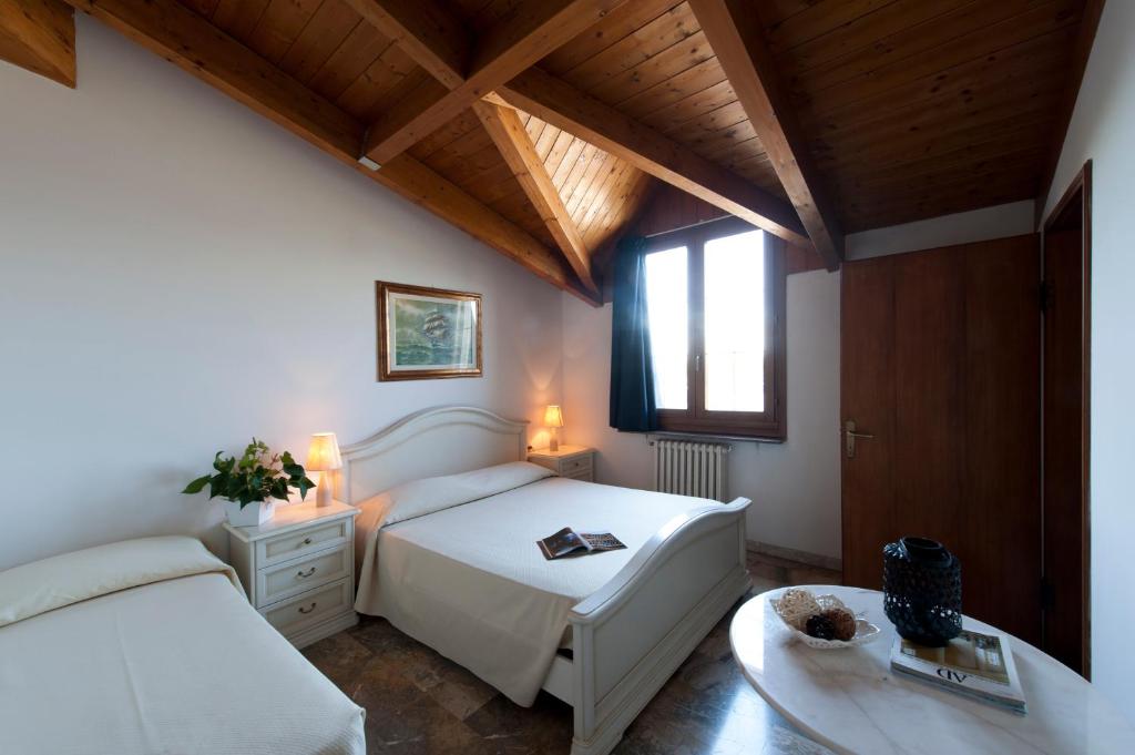 萨韦纳河畔圣拉扎罗卡塞勒酒店的卧室配有白色的床和窗户。