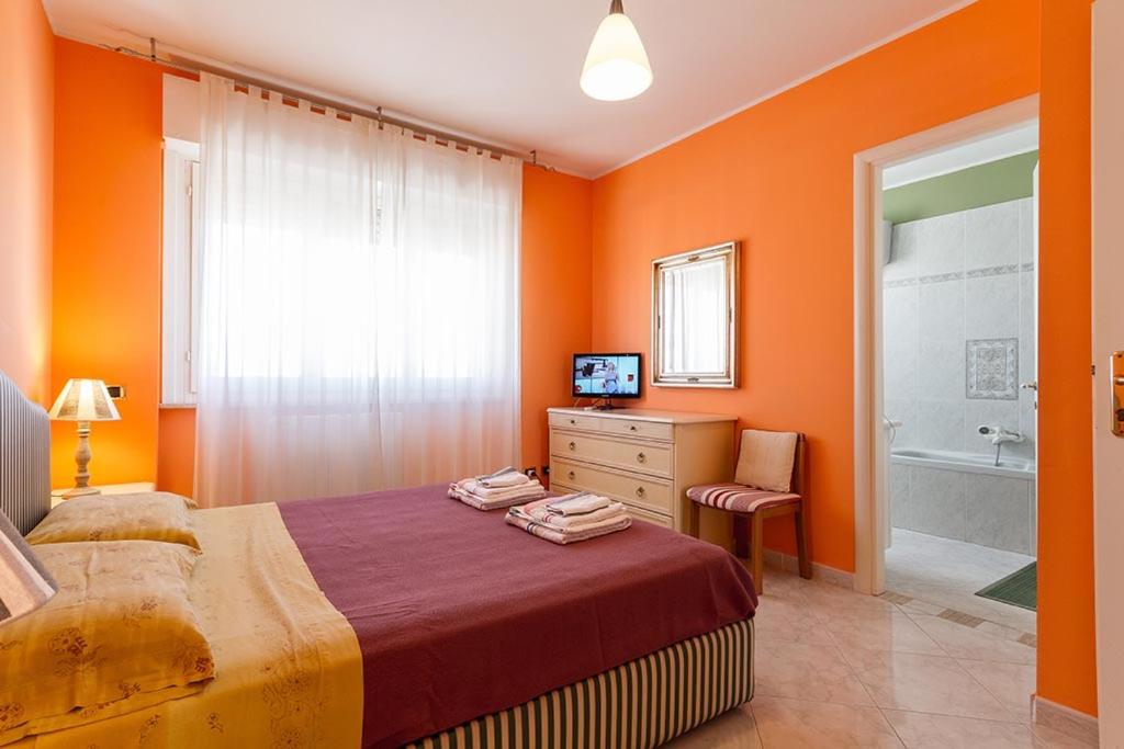 卡利亚里B&B Mareya的一间卧室设有橙色的墙壁、一张床和一个浴缸