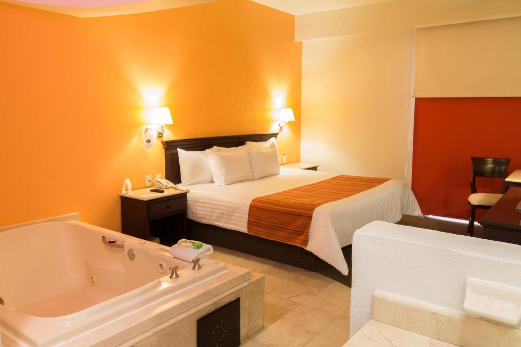 瓜达拉哈拉HG酒店的酒店客房配有一张床和浴缸。