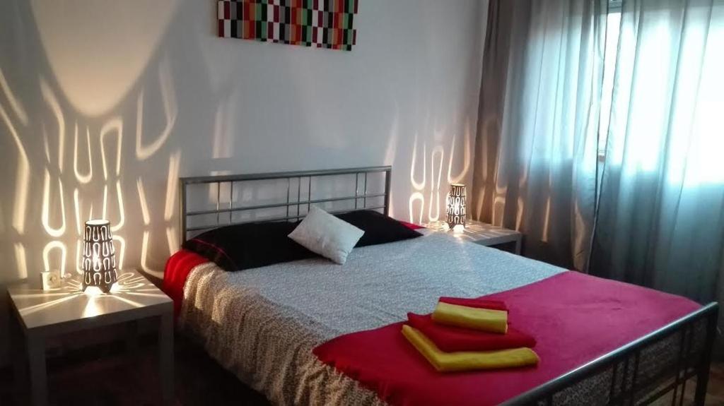 波尔图波尔图中心公寓的一间卧室配有一张带两盏灯和两条毛巾的床。