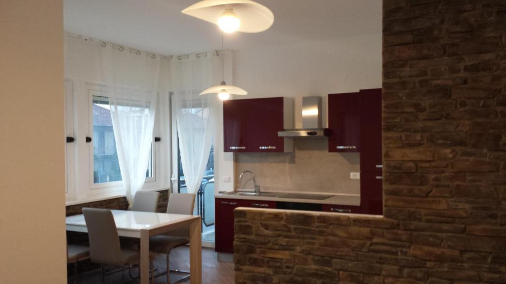 米兰尼斯利维因斯乔亚公寓的厨房配有桌椅和砖墙