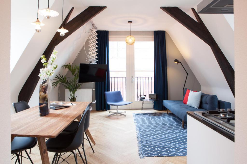 登博斯公爵精品公寓的客厅配有桌子和蓝色沙发