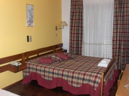 波尔蒂芒Sao Roque的一间卧室配有一张带铺着地毯的床和窗户。
