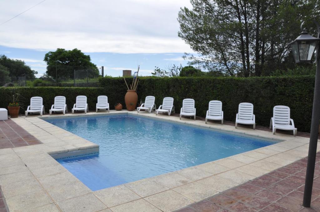 米娜克拉韦罗Hotel de la Cañada Mina Clavero的一个带椅子和一束椅子的游泳池