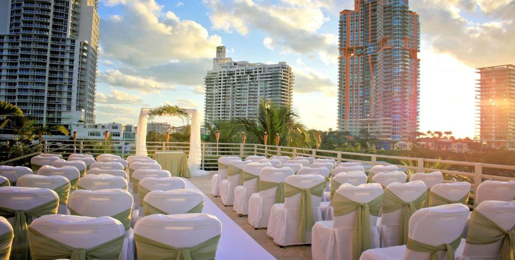 迈阿密海滩Hilton Bentley Miami South Beach的建筑物前一排白色的桌椅