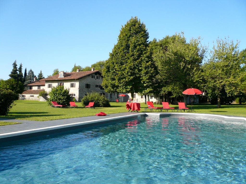 San Giovanni al Natisone博瑞迪卡瓦迪普乡村民宿的一个带红色椅子的游泳池
