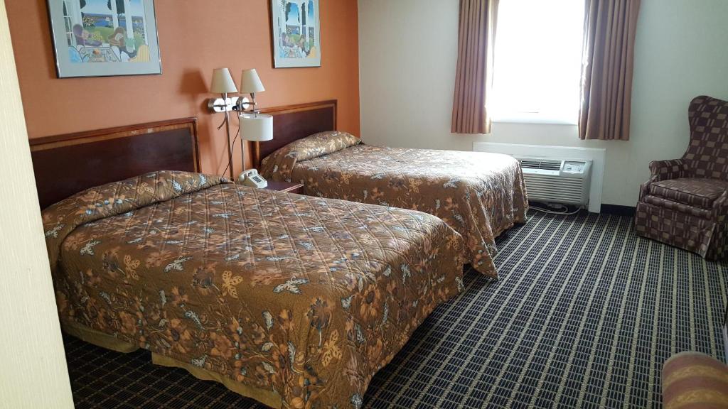 Woonsocket伍恩索切特酒店的酒店客房,配有两张床和椅子