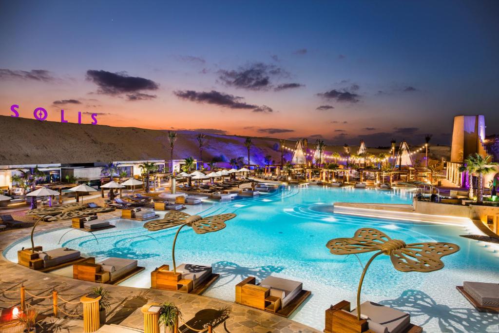 迪拜Terra Solis Dubai的一个带躺椅的大型游泳池,度假村