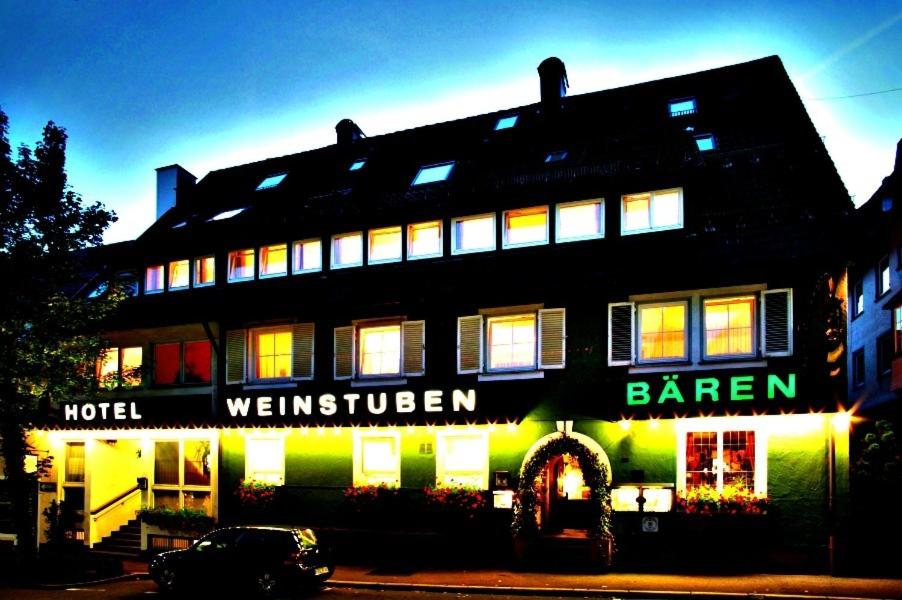 弗罗伊登施塔特巴伦餐厅酒店的黑色建筑,设有明亮的窗户和酒吧