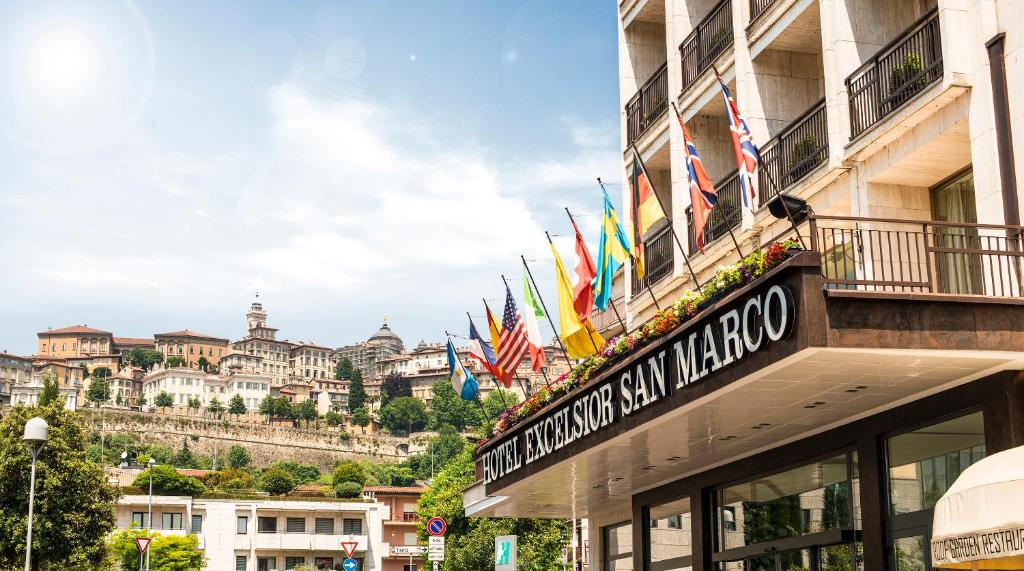 贝加莫圣马可高级酒店的大楼上挂有旗帜的酒店标志