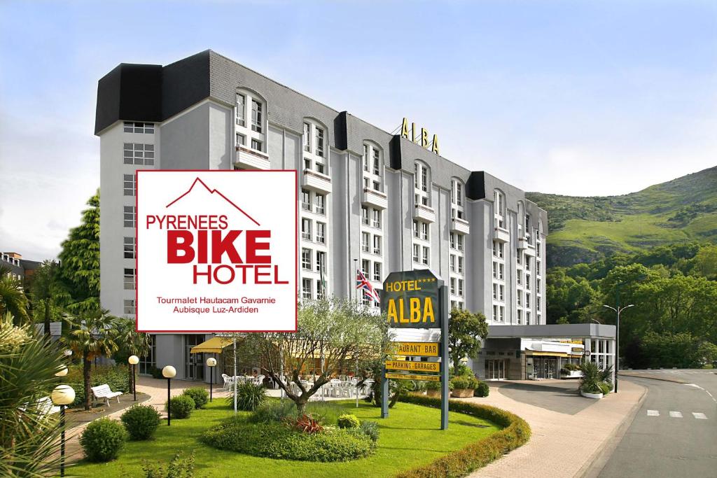 卢尔德阿尔巴酒店的一座大建筑,上面有自行车旅馆的标志