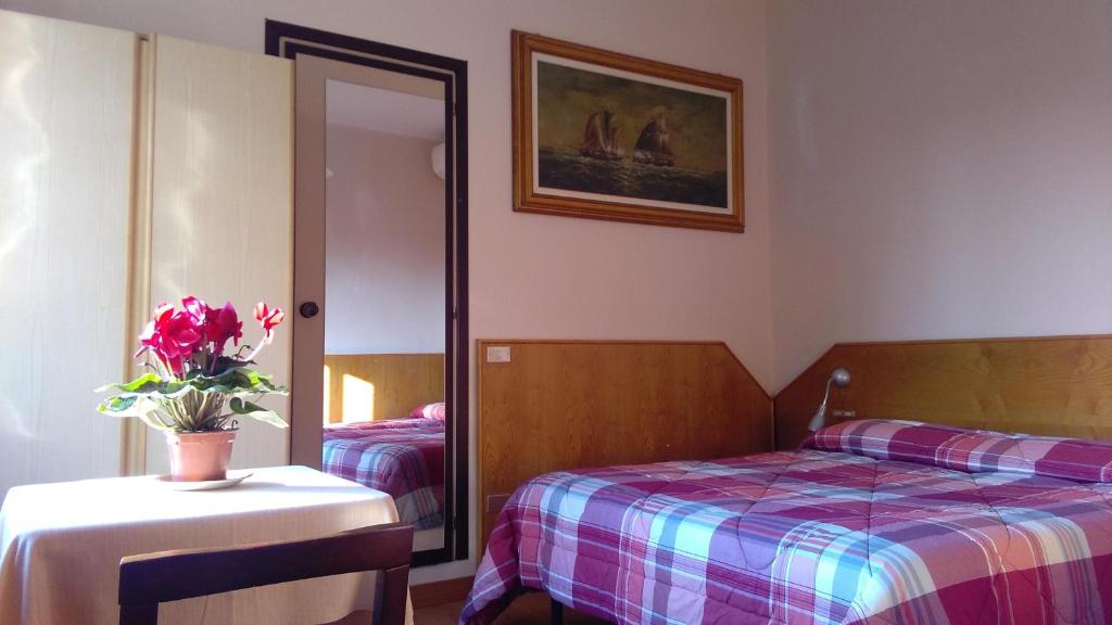 Lentate sul Seveso阿菲塔朱迪西旅馆的一间卧室配有一张床和一张花瓶桌子