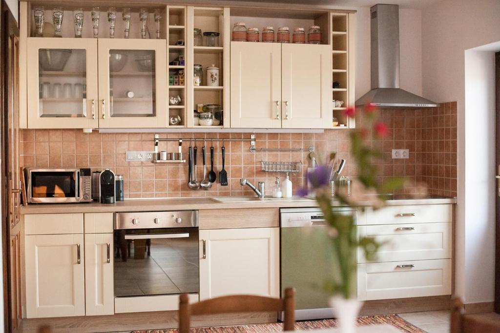 Véménd毛沙斯旅馆的厨房配有白色橱柜和炉灶烤箱。