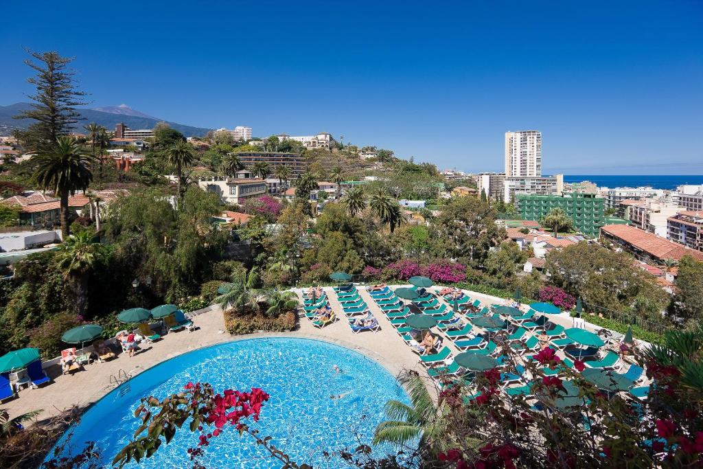 拉克鲁斯Hotel Atlantic El Tope的海滩上带椅子和遮阳伞的大型游泳池