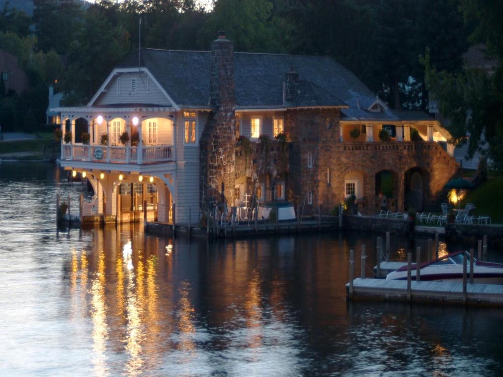 博尔顿兰丁Lake George Boathouse Waterfront Lodging的夜晚在水面上的大房子