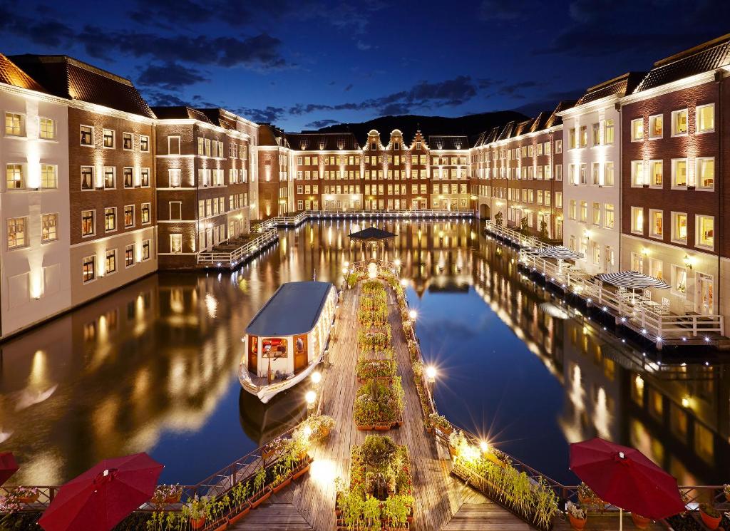 佐世保欧洲豪斯登堡酒店的一座在夜间有运河的大建筑