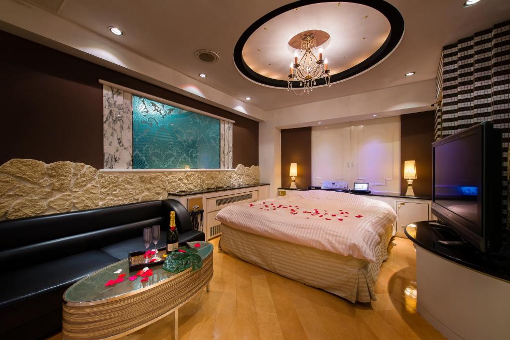 东京HOTEL PAL Otsuka -Adult Only-的一间卧室配有一张床、一张沙发和一台电视