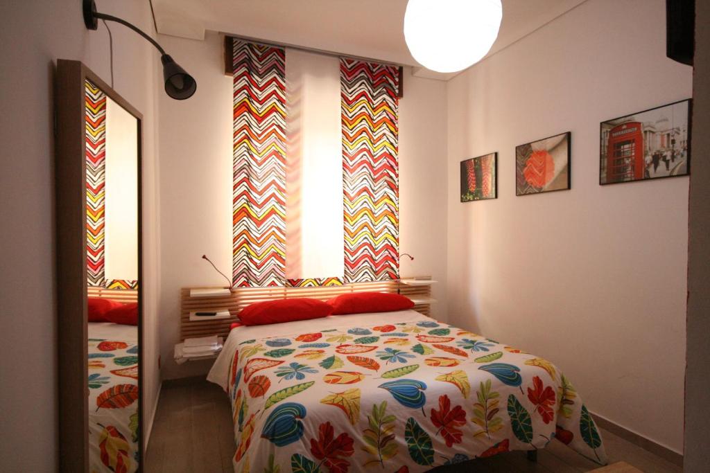 杰拉B&B Santiago的一间卧室配有一张带彩色毯子的床
