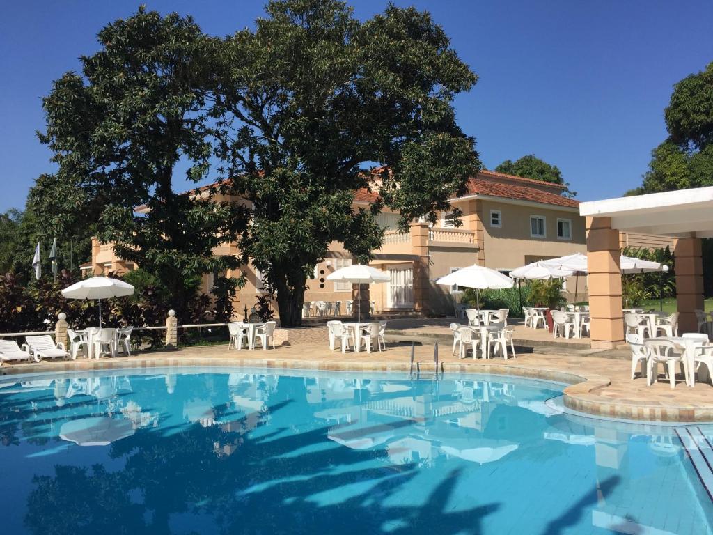 伊塔蒂亚亚伊塔蒂埃亚拉蓬萨酒店的一个带白色椅子和遮阳伞的游泳池