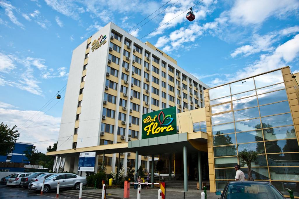 马马亚Hotel Flora的一座大型酒店建筑,天空中放风筝