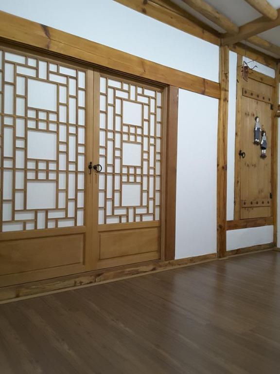 庆州耶陶尔韩屋旅馆的一间设有木门和木地板的客房