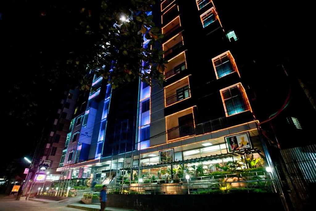 吉大港井柏住宅精品套房酒店的建筑的侧面有蓝色的灯光