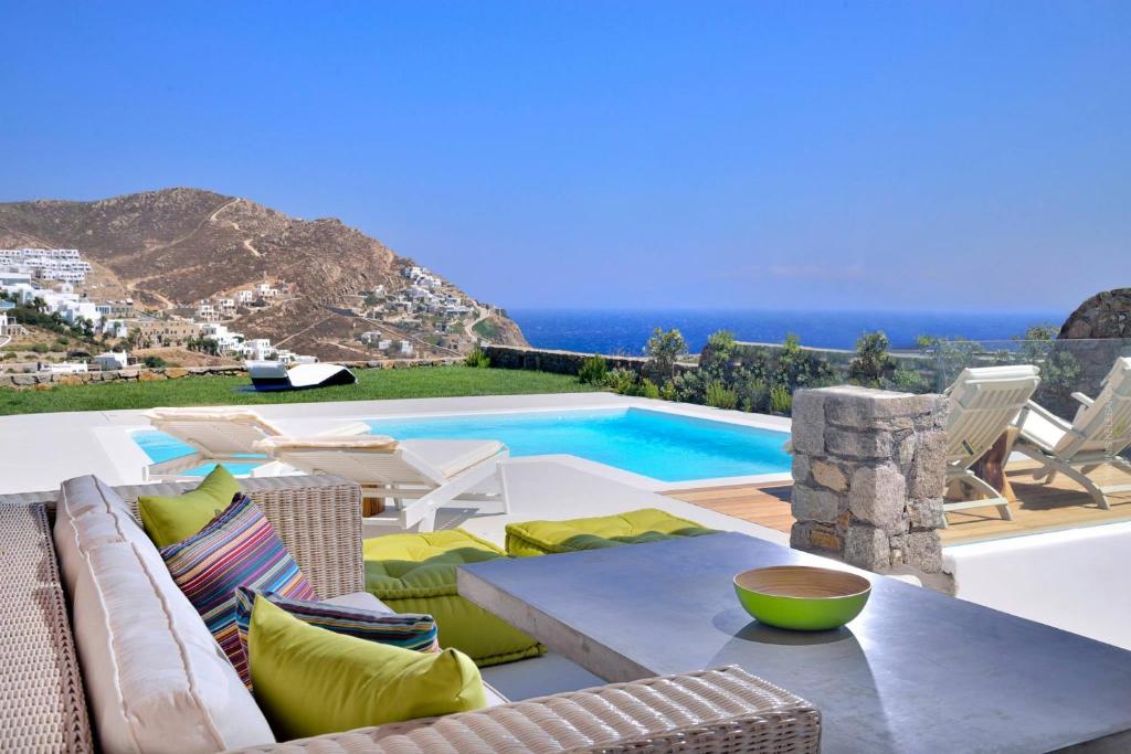 埃利亚海滩Villa Castalia by Thalassa Residence Mykonos的一个带桌椅的庭院和一个游泳池