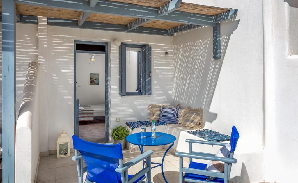 佐努萨岛Althea Studios的庭院配有蓝色的椅子、桌子和沙发