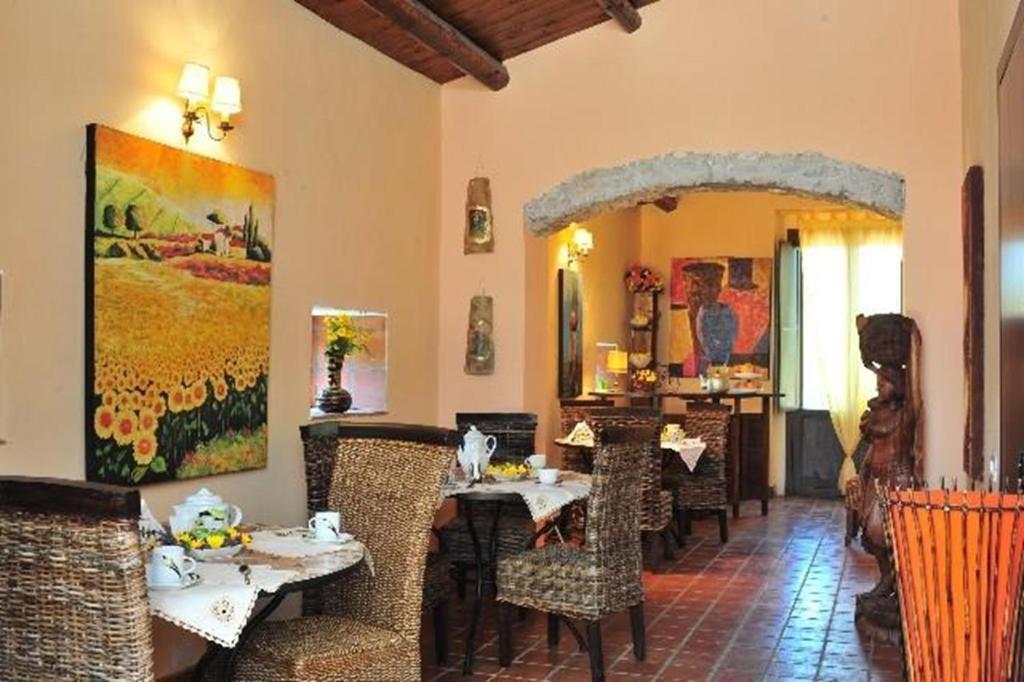 诺托Agriturismo Vita e Natura的餐厅设有桌椅和大镜子