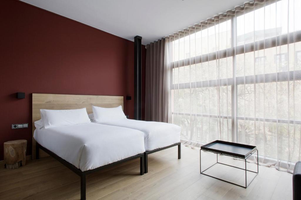 巴塞罗那阿拉达3号公寓的卧室设有白色的床和大窗户